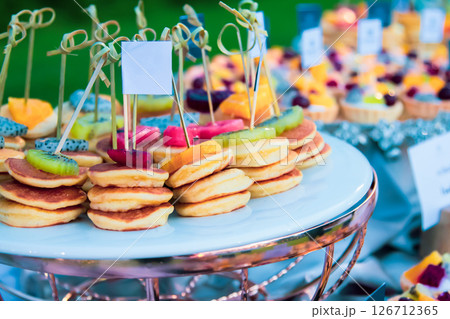 Dessert fruit pancakes at a wedding feast, food on a tray Dessert fruit pancakes at a wedding feast, food on a tray 126712365