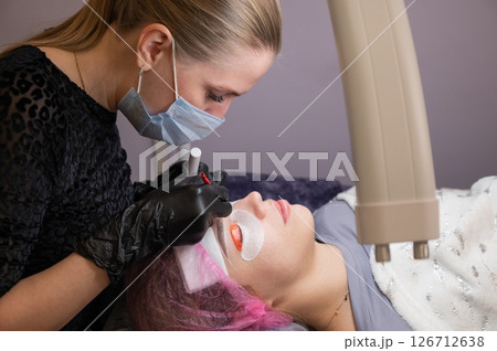 Caucasian woman undergoing eyelash lamination procedure. Caucasian woman undergoing eyelash lamination procedure. 126712638