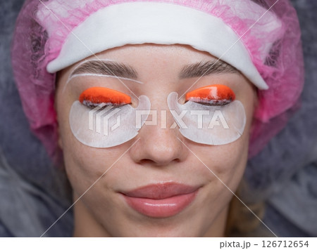 Caucasian woman undergoing eyelash lamination procedure. top view.  126712654