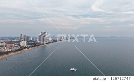 Pattaya city skyline dominating the coastline under cloudy sky 126712747