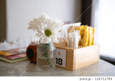 Beautiful white daisies on a table in a restaurant Beautiful white daisies on a table in a restaurant 126712769
