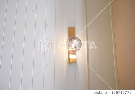 A small light bulb hangs on the wall of a restaurant 126712770