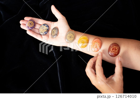 Healing crystals on female hand background, seven chakra stones 126714010