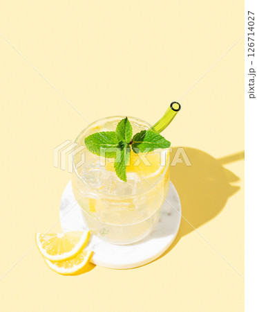 Fresh mocktail mojito with lemon, mint and ice. Citrus lemonade on a yellow background. Fresh mocktail mojito with lemon, mint and ice. Citrus lemonade on a yellow background. 126714027