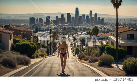 Scenic perspective of a person walking down a palm-lined residential street. California Dreaming Concept 126714403