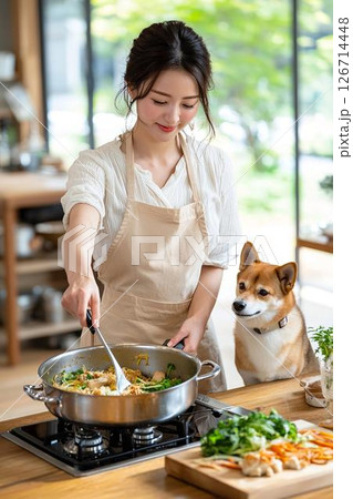 キッチンで犬の手作りご飯を作る女性、見つめる柴犬 126714448