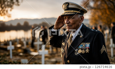 Senior military officer in full dress uniform with medals saluting at sunset in a cemetery with white crosses, showcasing dignity, respect and remembrance of fallen comrades. Senior military officer in full dress uniform with medals saluting at sunset in a cemetery with white crosses, showcasing dignity, respect and remembrance of fallen comrades. 126714616
