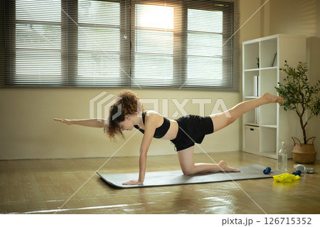 Female athlete stretching on a yoga mat. Home workout concept 126715352