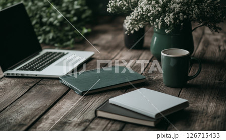 Home workplace with laptop, vase of flowers, coffee cup on wooden table, background 126715433