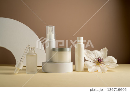 Blank cosmetics jars and bottles with white flower. Beauty concept, neutral background 126716603