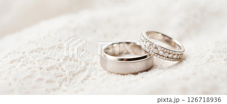 Elegant wedding rings displayed on soft lace fabric, love symbolism 126718936