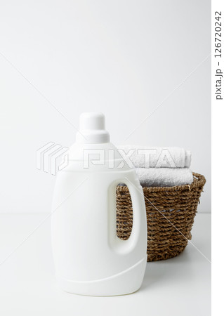 Laundry detergent branding mock up and basket filled with clean white towels. Household cleaning and hygiene concept concept packaging 126720242