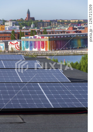 Solar panels on roof of apartment housing building with Gothenburg city center in background, Sweden, renewable green sustainable energy concept 126721309