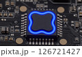 A close up shot of a modern computer chip with a blue outline on a dark circuit board 126721427