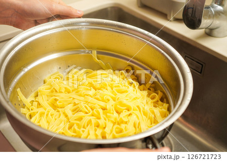 調理したタリアテッレをザルにあげて水を切っているところ 126721723