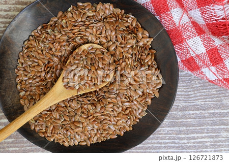 Flax seeds. Flaxseed powder in a wooden spoon. Standing on a Wooden background. Flax seeds. Flaxseed powder in a wooden spoon. Standing on a Wooden background. 126721873