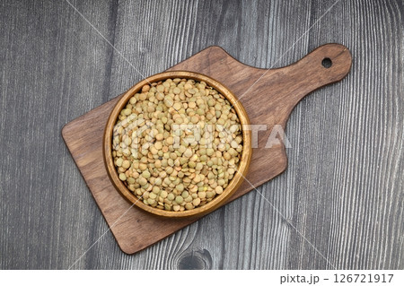 Green lentils in wooden bowl on wooden table background. Top view, copy space. Flat lay. 126721917