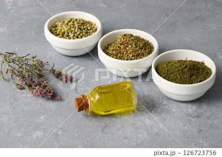 thyme(Oregano) essential oil and Heap of dry thyme in wooden spoon and in bowl on wooden background thyme(Oregano) essential oil and Heap of dry thyme in wooden spoon and in bowl on wooden background 126723756
