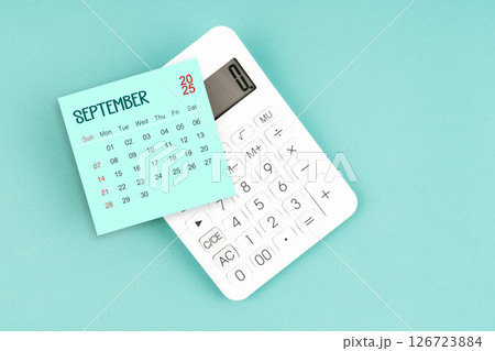 September 2025 calendar card with calculator on blue background. 126723884