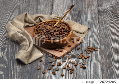 Wooden bowl with coffee beans on wooden background Wooden bowl with coffee beans on wooden background 126724205