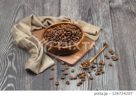 Wooden bowl with coffee beans on wooden background 126724207