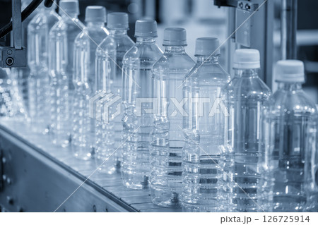 The full filled drinking water bottles on the conveyor belt in the light blue scene. The full filled drinking water bottles on the conveyor belt in the light blue scene. 126725914