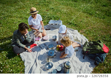 Family Enjoying a Sunny Picnic Day Together Outdoors in Summer Nature 126726358