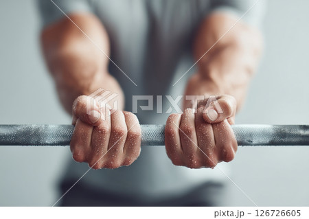 A close-up view of hands gripping a barbell showcasing strength training in a gym. A close-up view of hands gripping a barbell showcasing strength training in a gym. 126726605