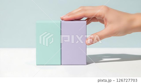 Womans hand touching pastel boxes 126727703