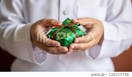 Childs Hands Holding Eid Gift Childs Hands Holding Eid Gift 126727730