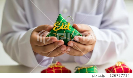 Childs Hands Holding Eid Ketupat Childs Hands Holding Eid Ketupat 126727734