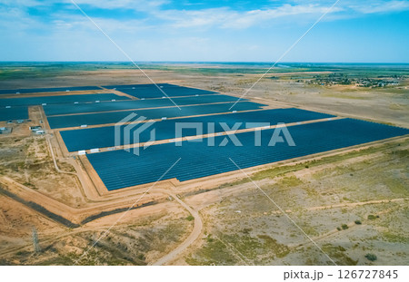 Solar energy farm located in a vast arid landscape generating renewable energy under clear blue skies 126727845