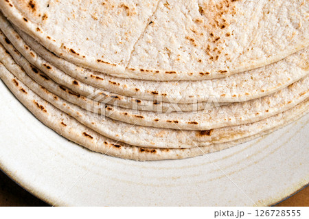 Stack of bread tortillas on beige kitchen plate close-up 126728555