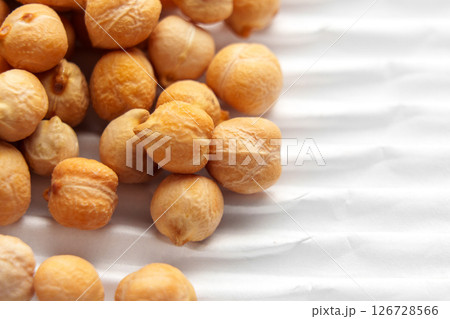 Raw chickpeas on packaging white ribbed paper. Uncooked grocery ingredient. Macro shot. Raw chickpeas on packaging white ribbed paper. Uncooked grocery ingredient. Macro shot. 126728566