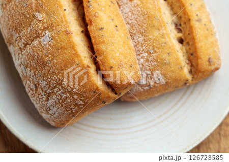 Freshly toasted fluffy wheat buns on a kitchen plate. Cracked bread. Top view. Freshly toasted fluffy wheat buns on a kitchen plate. Cracked bread. Top view. 126728585
