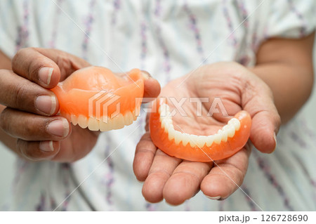 Asian senior woman holding denture teeth. 126728690