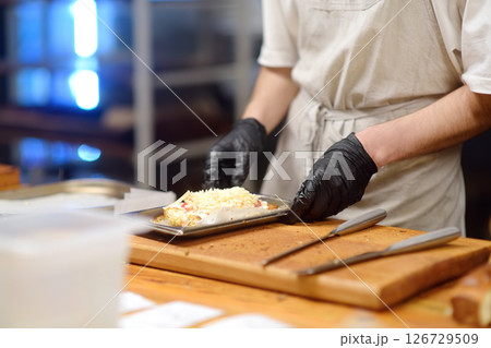Close-up view of a restaurant or cafe kitchen and workers preparing food for customers. Close-up view of a restaurant or cafe kitchen and workers preparing food for customers. 126729509