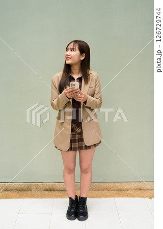 portrait of a young woman using phone 126729744