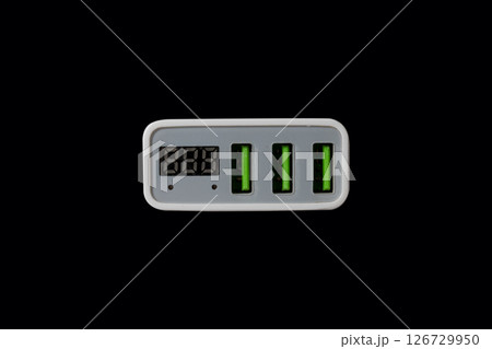 USB adapter for charging multiple mobile phones and modern devices on a black background 126729950