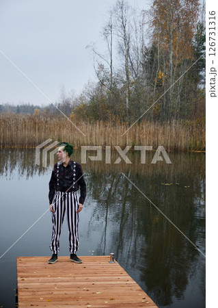 A Mysterious Character Standing upon a Dock Surrounded by Tranquil and Serene Waters A Mysterious Character Standing upon a Dock Surrounded by Tranquil and Serene Waters 126731316