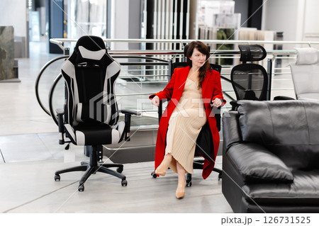 Elegant woman trying new office chairs in furniture store Elegant woman trying new office chairs in furniture store 126731525