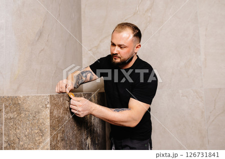 Construction worker installing tiles in a new modern bathroom 126731841