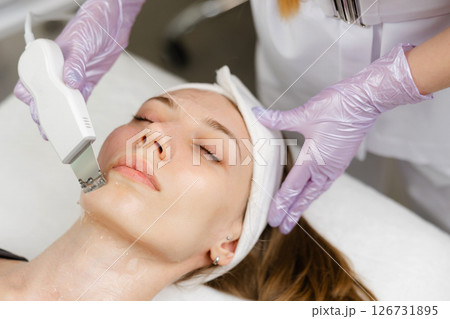 Beautician performing ultrasonic facial cleansing on woman Beautician performing ultrasonic facial cleansing on woman 126731895