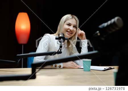 Smiling woman recording podcast in home studio 126731978