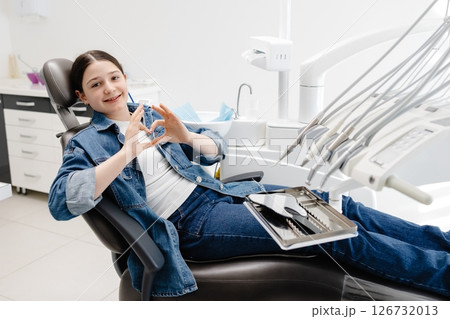 Young Patient Showing Heart Sign with Hands at Dentist Office 126732013