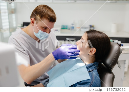 Dentist preparing dental impression tray for young patient Dentist preparing dental impression tray for young patient 126732032