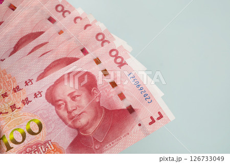 Large stack of Chinese yuan banknotes on blue background. Copy space. Close up. 126733049