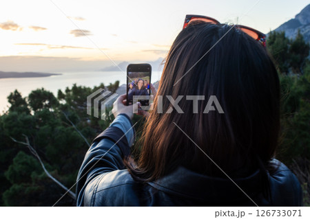 Tourist taking a selfie at sunset. Summer tourism with friends. Lifestyle Tourist taking a selfie at sunset. Summer tourism with friends. Lifestyle 126733071