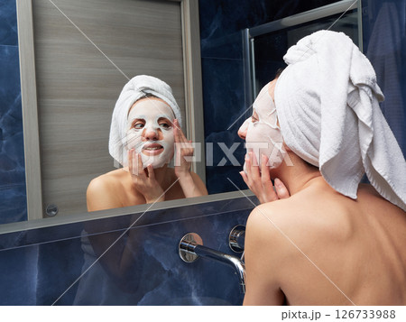 Woman put face mask at bathroom 126733988
