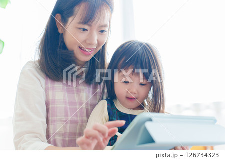 タブレットで遊ぶ女の子と保育士 126734323